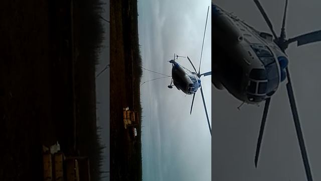 Вертолет берет трубы на подвеску.