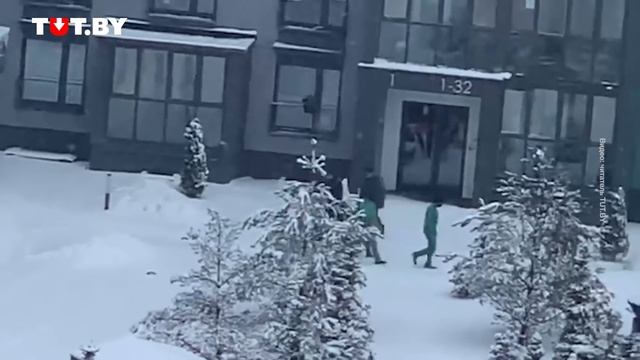 Люди в красно-зеленых костюмах бросают снежки в окна в Новой Боровой