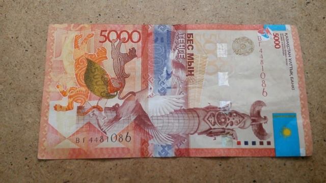 БАНКНОТА 5000 ТЕНГЕ № серии ВГ4481086 на крагисной поверхности Четвёртого Марта - ДЕНЕЖНЫЙ ПОТОК