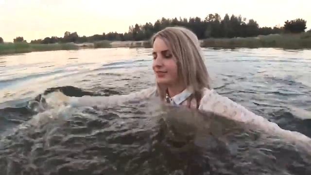 Девушка в колготках и юбке гуляет в воде
