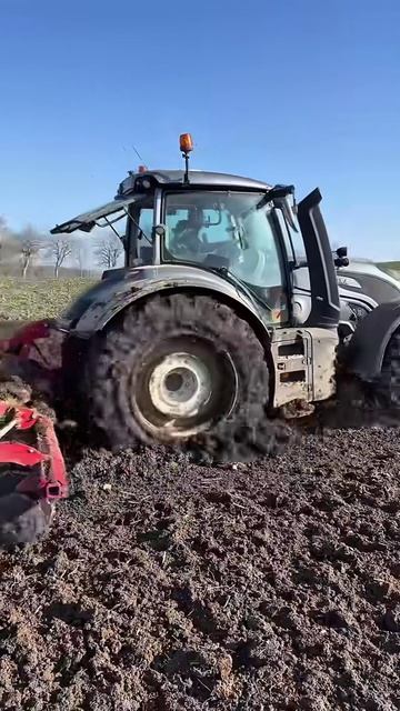 Трактор Valtra 🚜 работает в тяжелых полевых условиях.