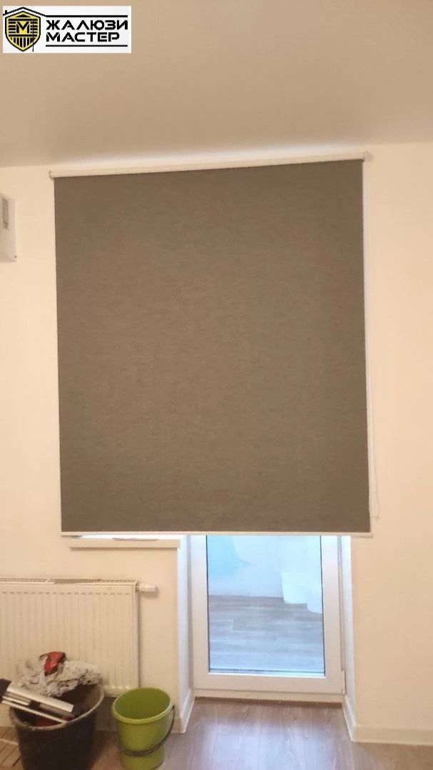 Темно-серые рулонные шторы блэкаут для защиты от яркого солнца.