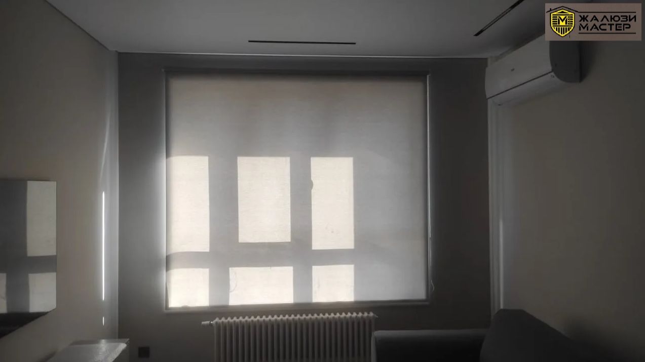 Полупрозрачные рулонные шторы серого цвета для регулирования уровня освещенности и приватности.