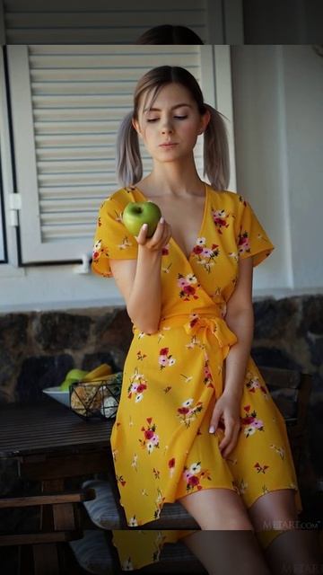 Eva Elfie в  жёлтом халате ест яблоко GIF