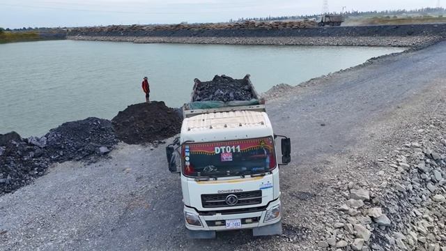 New Project Of Pouring Rocks Into The Deep Lake Water  With A Team Of Machinery Working Skillfully
