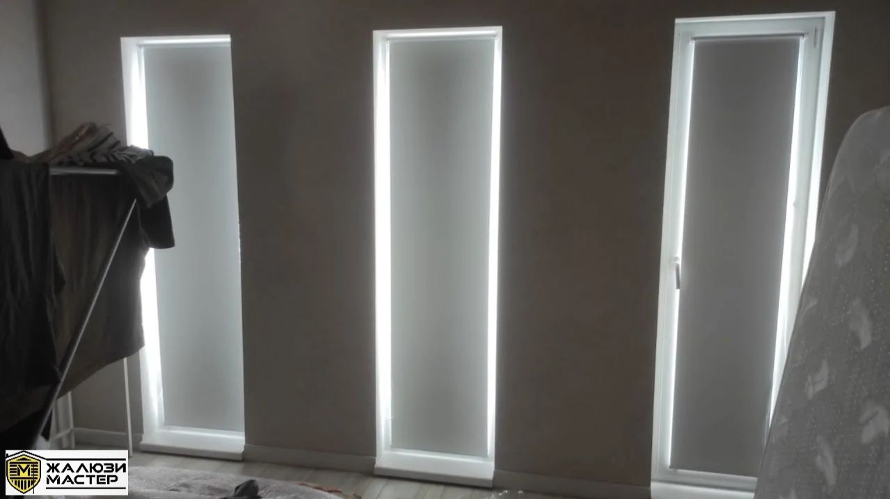 Белые рулонные шторы MINI BLACK-OUT для защиты от солнца для полноценного сна и отдыха в спальне.