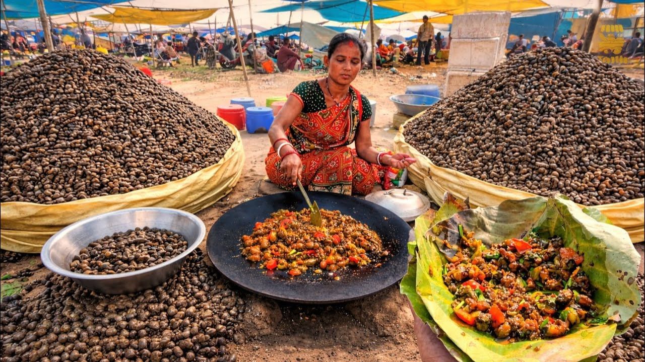 Традиционное карри из улиток, приготовленное в свежем виде на оживленном индийском рынке