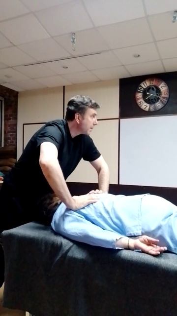 Клиент делает сам себе массаж при помощи энергетики массажиста