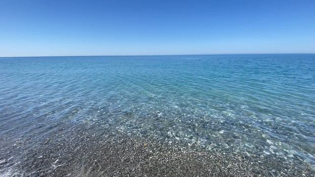 Штиль на море. Вода прозрачная, прогулка вдоль берега