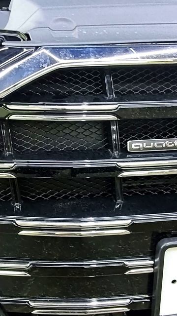 Детальный снимок решетки радиатора Audi с фирменным логотипом Quattro. Отлично подойдет для демонстр