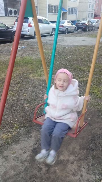 Доча качается на качели и поет песню