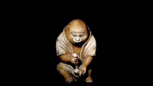 Обезьяна вырезает нэцкэ Хотея