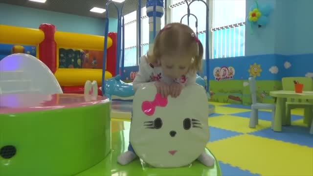 Настя играет в парке аттракционов