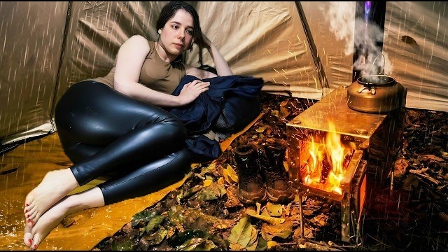 Кемпинг девушки в палатке под проливным дождем. Приготовление пищи в уютной дровяной печи. Бушкрафт