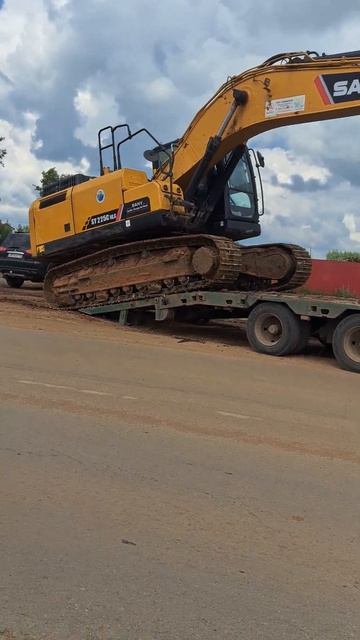 The excavator drives onto the lowboy