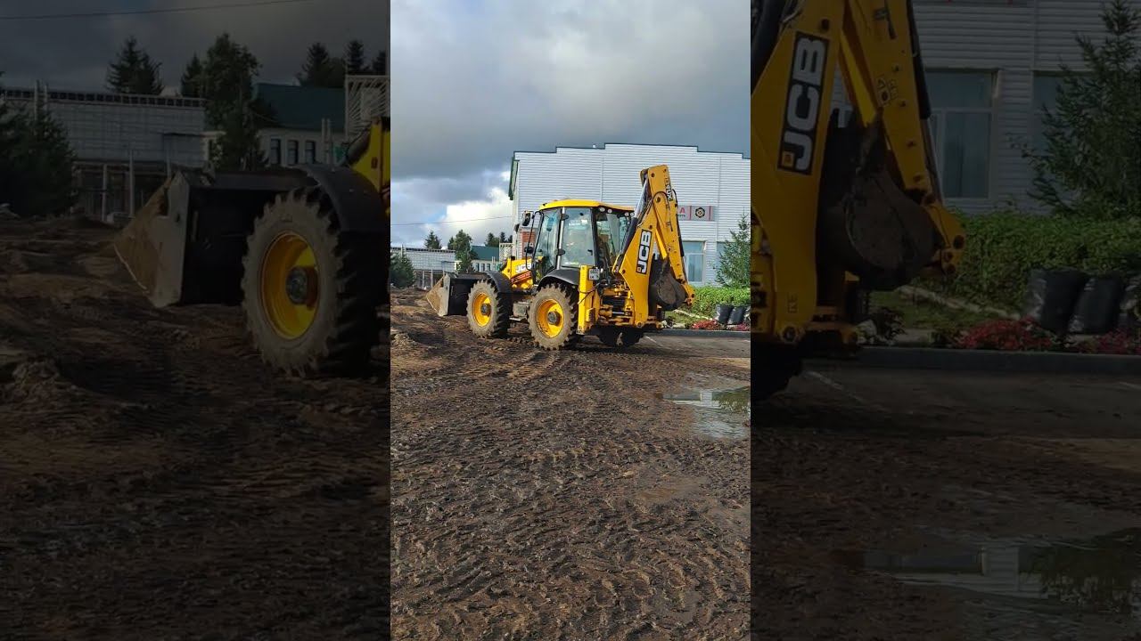 A yellow excavator tractor works at a construction site.