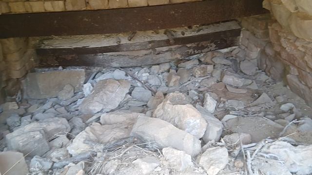 Арочный каменный свод подземелья в горе Алчак-Кая с обрезанными силовыми кабелями кирпичной забутовк