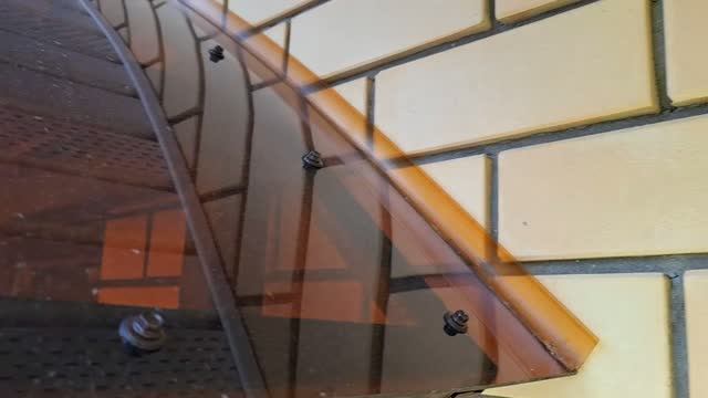 Установить планки примыкания на стык арочной крыши балкона и стены дома.