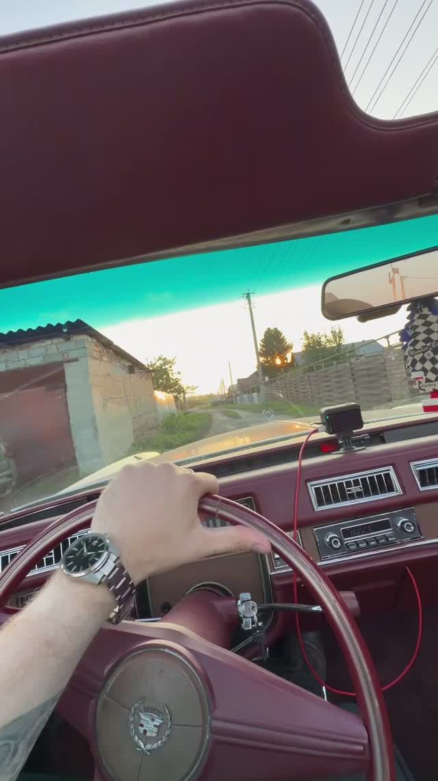 Cadillac 1975 года едет по российской деревне 