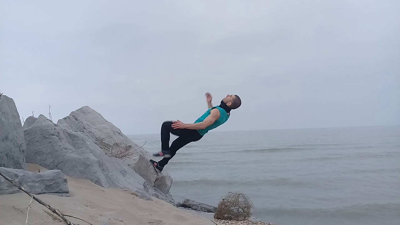 Сальто назад от камня на берегу моря