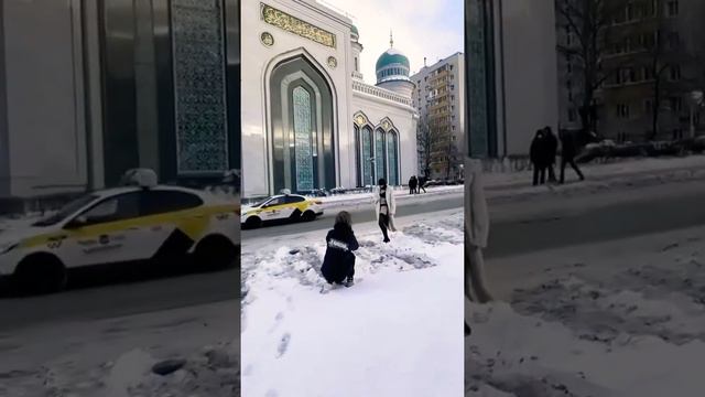 Девушка в чулках и балаклаве фотографируется на фоне Соборной мечети