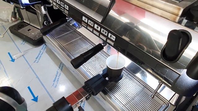 Робот - бариста готовит кофе на профессиональной кофемашине и кофемолке