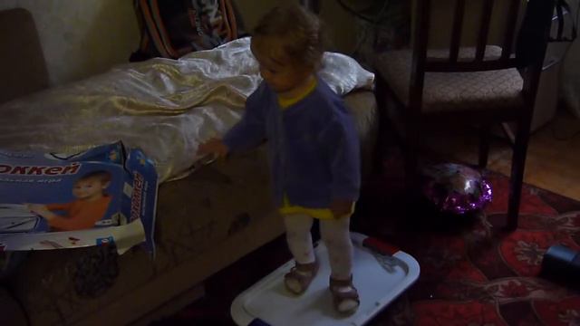 Маленькая девочка танцует, поёт и играет на гармошке.