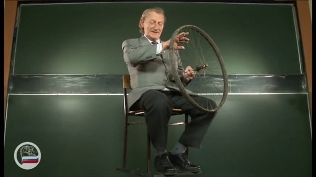 Человек на скамье Жуковского с велосипедным колесом