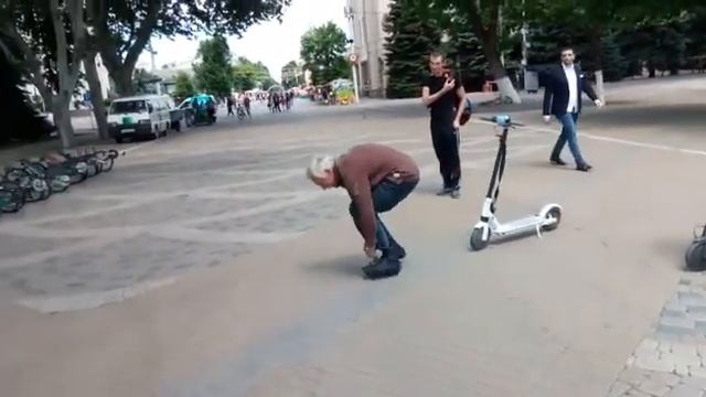 Мужчина катается на очень маленьком  велосипеде.