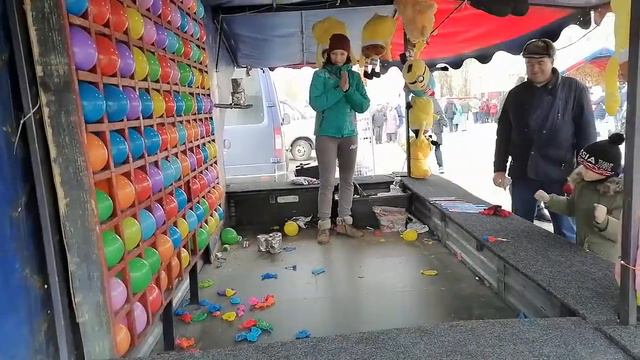 Быстрый человек стреляет дротиками в шарики.