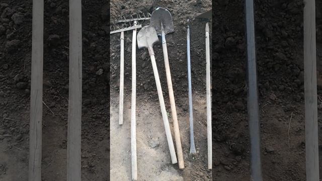 Шесть инструментов лежат на выкопанной земле 14-ого Мая - это двое грабель, две лопаты, лом и тяпка