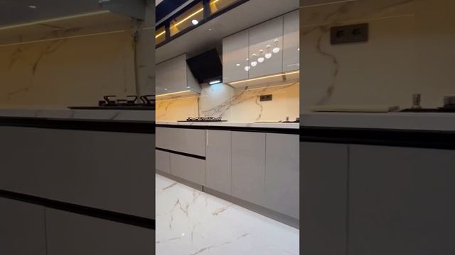 Современная угловая глянцевая бежевая кухня с высокими витринами и чёрной столешницей  #кухни