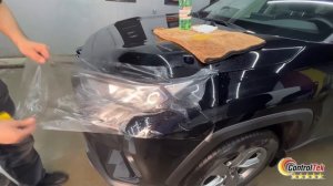 Процесс наклеивания защитной пленки на фары автомобиля.