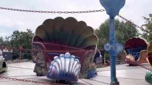 Юный Весельчак катается на Ракушках в парке аттракционов