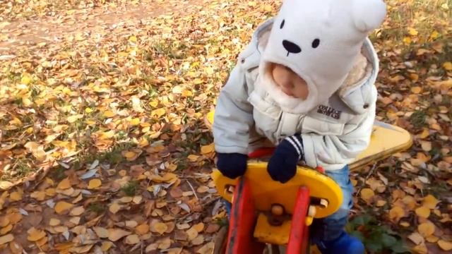 Денис гуляет на площадке, качается на  мотоцикле.