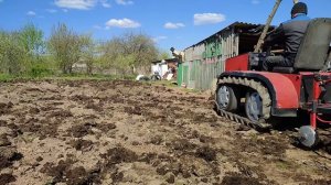 Гусеничный минитрактор работает на участке .