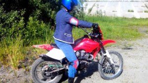 Девушка заводит мотоцикл с кика