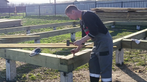 Начало строительства каркасного дома. Обвязка свай брусом.