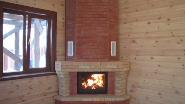 Угловой камин с чугунной топкой и отделкой из облицовочного и шамотного кирпича. смотреть онлайн