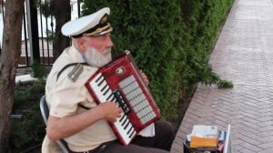 Уличный музыкант играет на аккордеоне