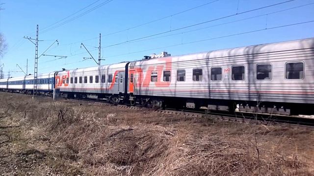 Пассажирский поезд проезжает железнодорожный переезд недалеко от Хасанской улицы в поезде Мартиросян