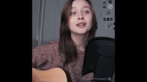 Милая девушка красиво поет и играет на гитаре.