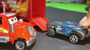Pixar Cars toys, mack trucks carrying Lightning McQueen, Jackson Storm, police cars,