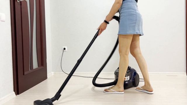 A girl in a blue skirt cleans the house with a bagless vacuum cleaner. Bosch BGS21X320 смотреть онлайн
