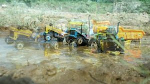 Тракторята тянут грузовик из грязи