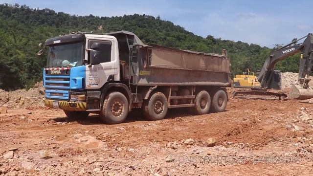 Volvo EC300Dl Excavator Digging Rock In To Scania Dump Trucks