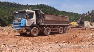 Volvo EC300Dl Excavator digging rock in to Scania dump trucks