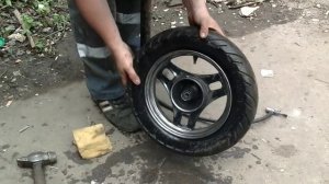 Бортируем шину на скутер молотком.