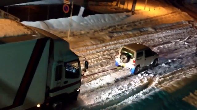 Маленький автомобиль вытаскивает фуру из снега смотреть онлайн