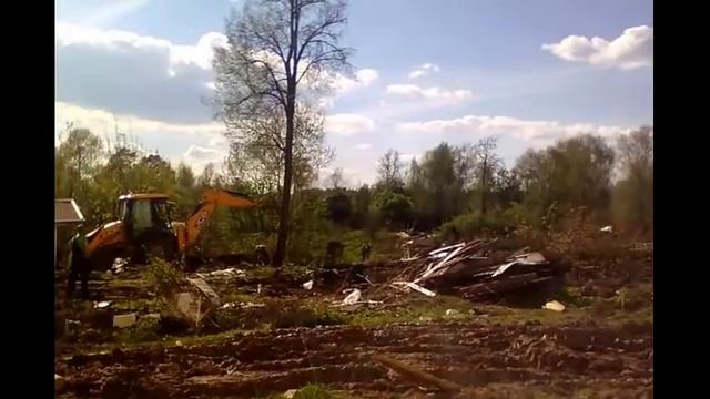 Бульдозер ковшом валит дерево. Начало строительства парка. Очистка территории. смотреть онлайн